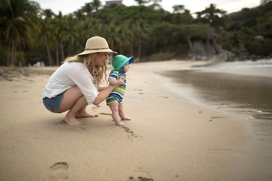 Baby's first trip to the beach with mama, wearing sunhats